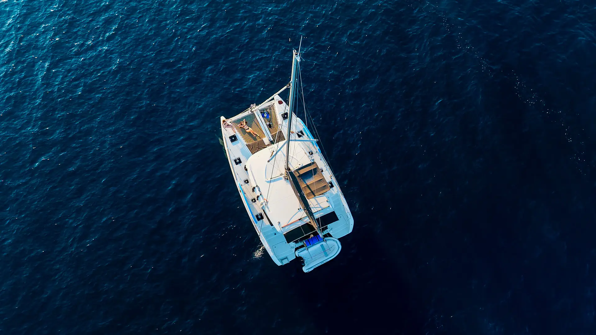 FW__077 Aerial view of catamaran sailing in deep blue sea